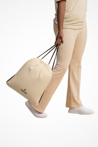 Blush coral lightweight drawstring bag with Gymplode dual mark imprint, front view with model