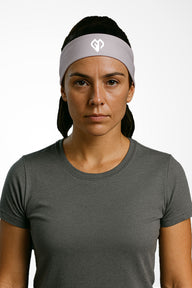 Lilac grey Gymplode headband with icon logo, worn by female model