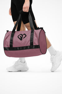 Rosewood rounded end Gymplode duffle bag with icon logo, front view with model