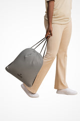 Smoke grey lightweight drawstring bag with Gymplode dual mark imprint, front view with model