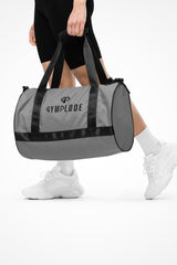 Smoke grey rounded end Gymplode duffle bag with dual mark, front view with model