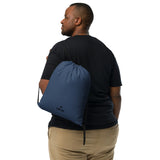 Storm blue lightweight drawstring bag with Gymplode dual mark imprint worn as backpack by male model